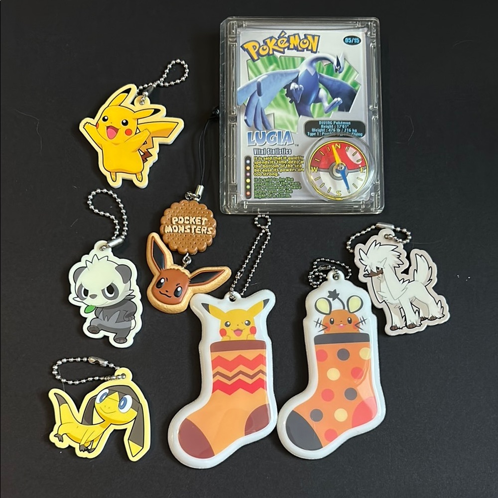 Bundle of assorted Pokémon keychains and Lugia compass card